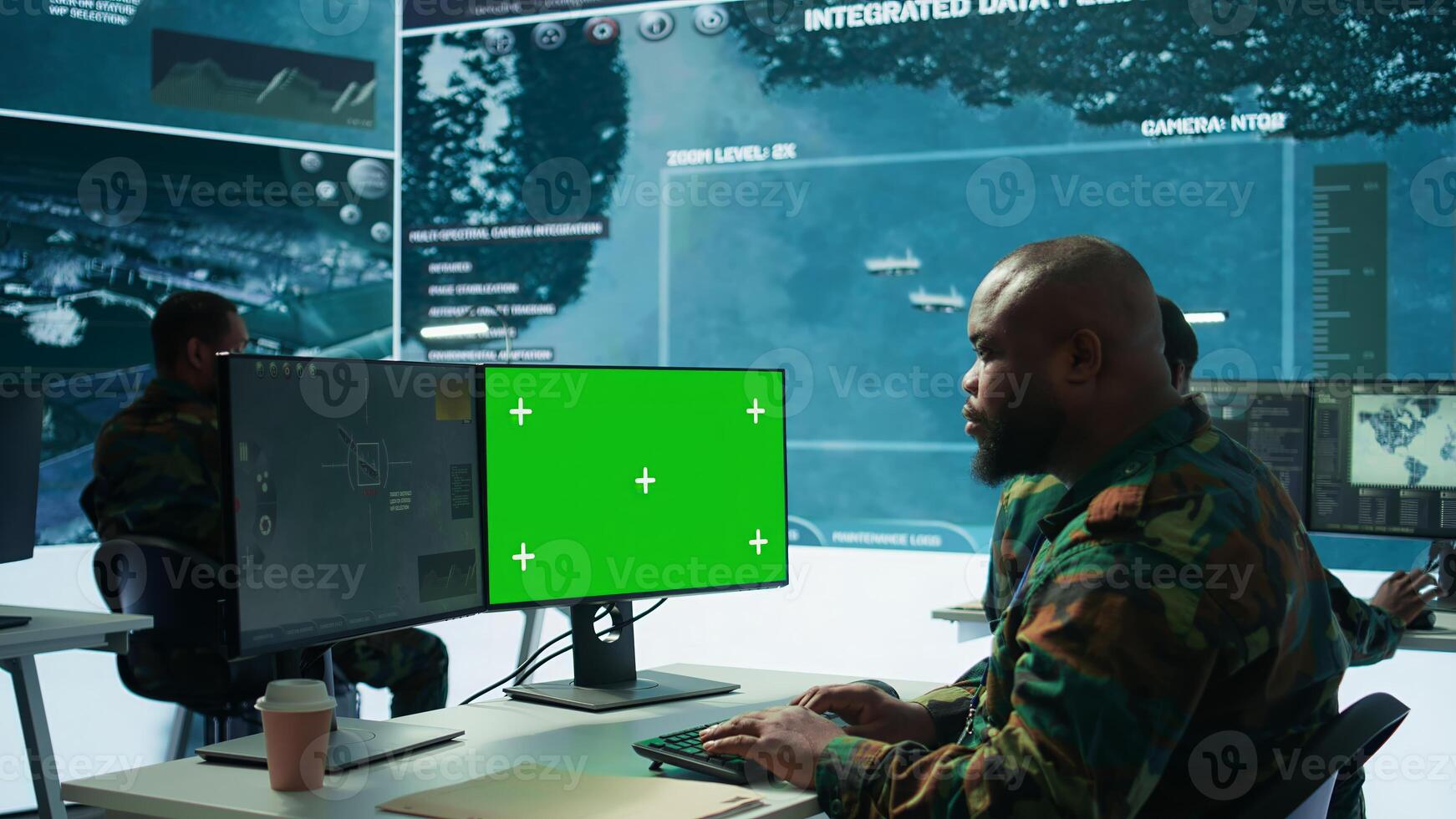 Military expert handles satellite cctv data next to mockup screen, working in a base of operations with high tech gear to support important defense missions. Coordinates strategic tactics. Camera B. photo