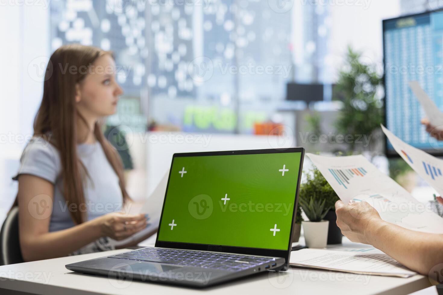 Portfolio Manager analyzing economic reports on isolated screen laptop, discussing with clients. Financial advisor uses chroma key notebook to help customers looking to grow their wealth photo