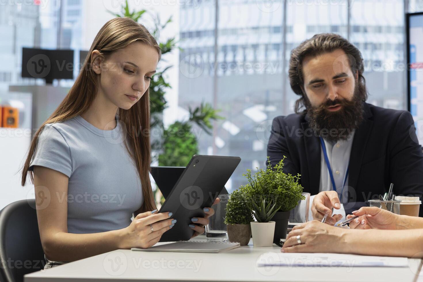 Portfolio Manager in office meeting analyzing economic reports, discussing with gen Z girl wanting to invest. Financial advisor helping young adult looking to increase wealth photo