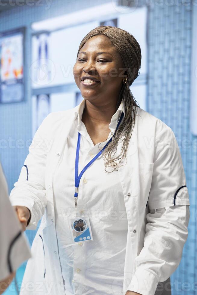 Diverse medics shaking hands after a successful treatment plan collaboration during a meeting with licensed physicians. Doctors with expertise doing a handshake for great partnership in office. photo