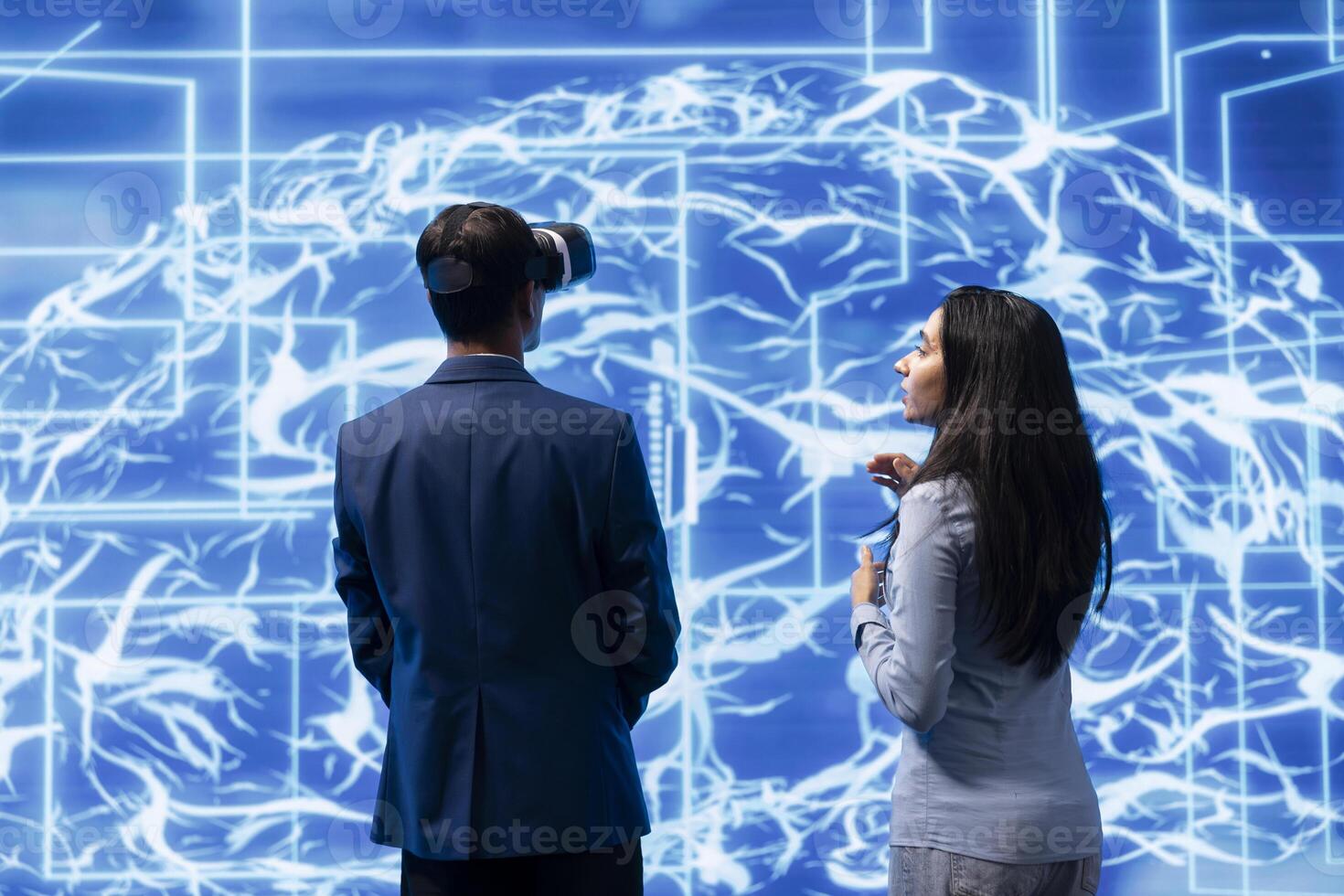 IT staff members using VR headset and artificial intelligence computing simulating human brain thought processes. Colleagues building AI machine learning algorithms using virtual reality photo