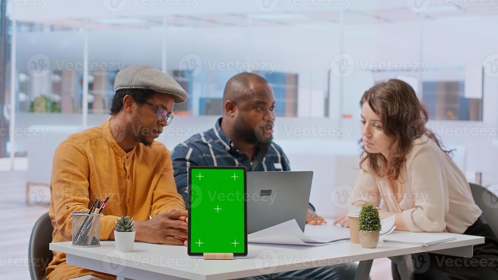 People discussing with the salesman next to chroma key screen on tablet, meeting to evaluate blueprints for a new office space. Business partners investing in real estate with financier. Camera B. photo