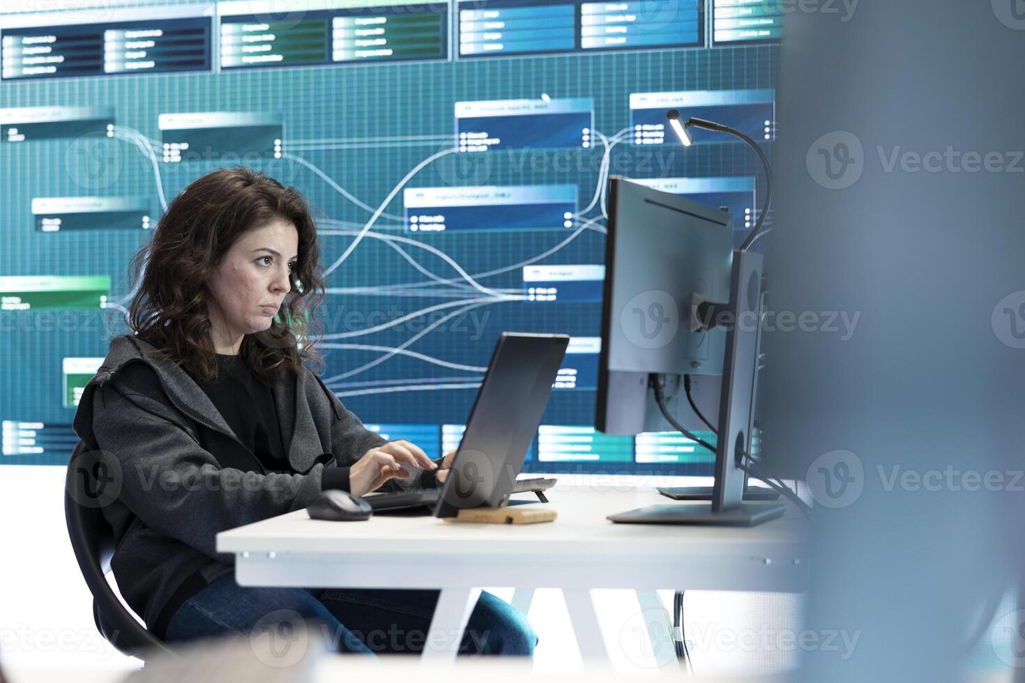Female governmental hacker examines data on a computer in agency center, using advanced technology to secure national servers. Working on cyber security and defending against threats. photo