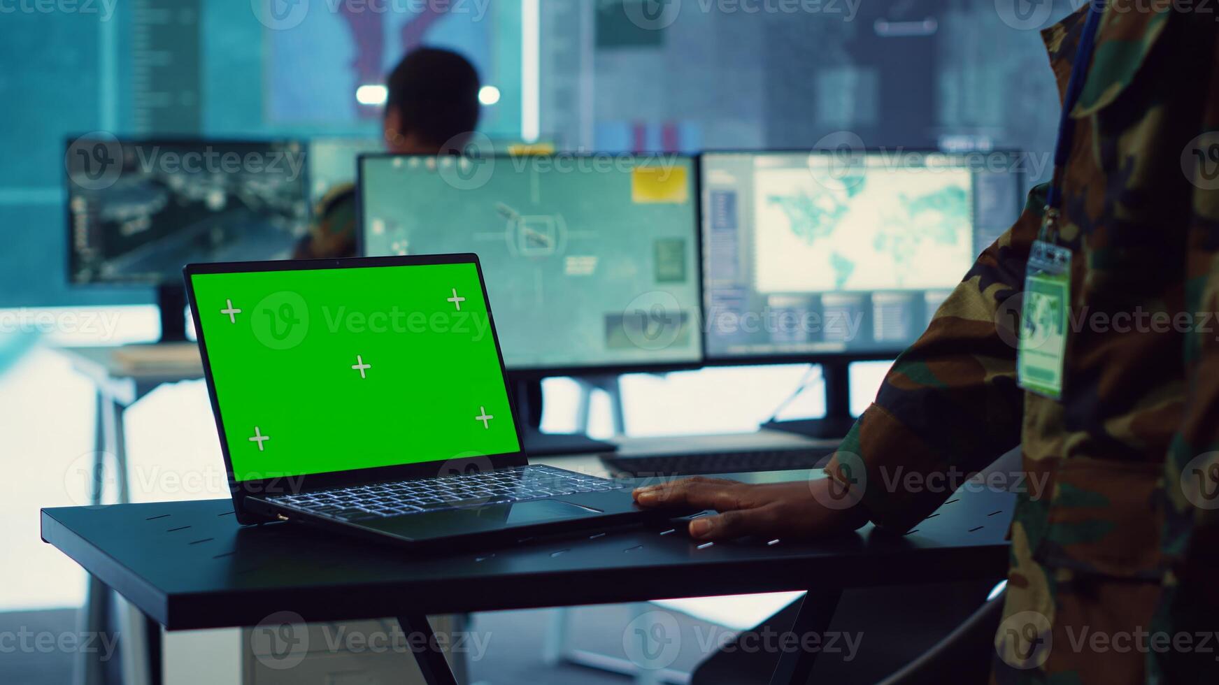 Commander examines a greenscreen on laptop in military command center, reconnaissance army division. Operator gathering intelligence from the field, transmitting real time data. Camera A. photo