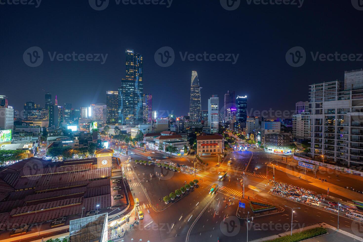 Night view of busy traffic in crowded intersection near Ben Thanh market in Ho Chi Minh city. Ben Thanh market is the symbol of Saigon, Vietnam photo