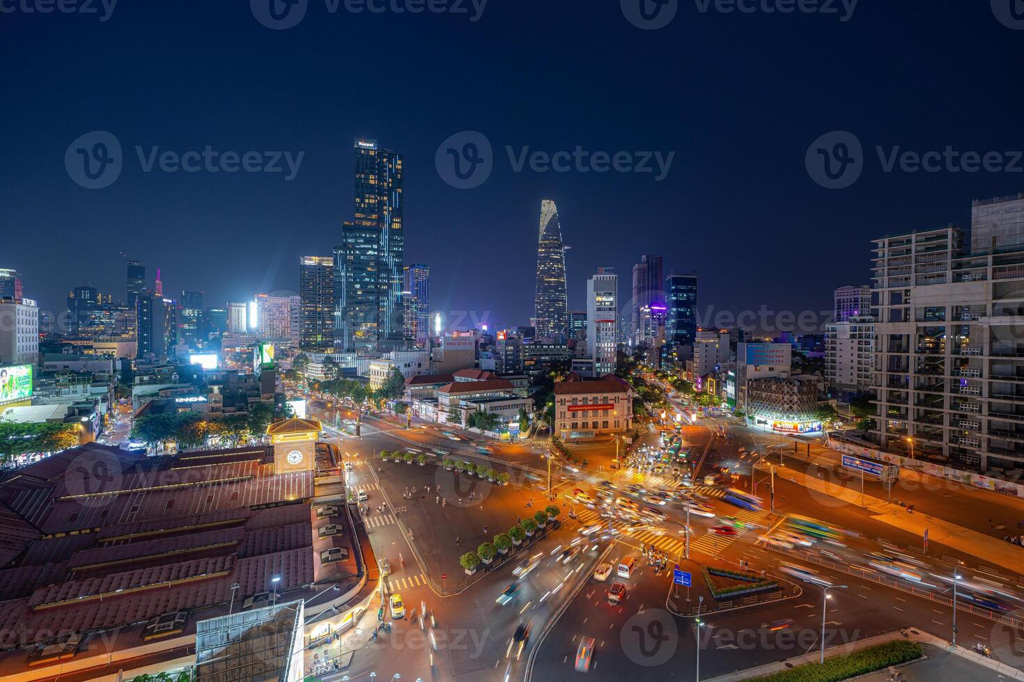 Night view of busy traffic in crowded intersection near Ben Thanh market in Ho Chi Minh city. Ben Thanh market is the symbol of Saigon, Vietnam photo