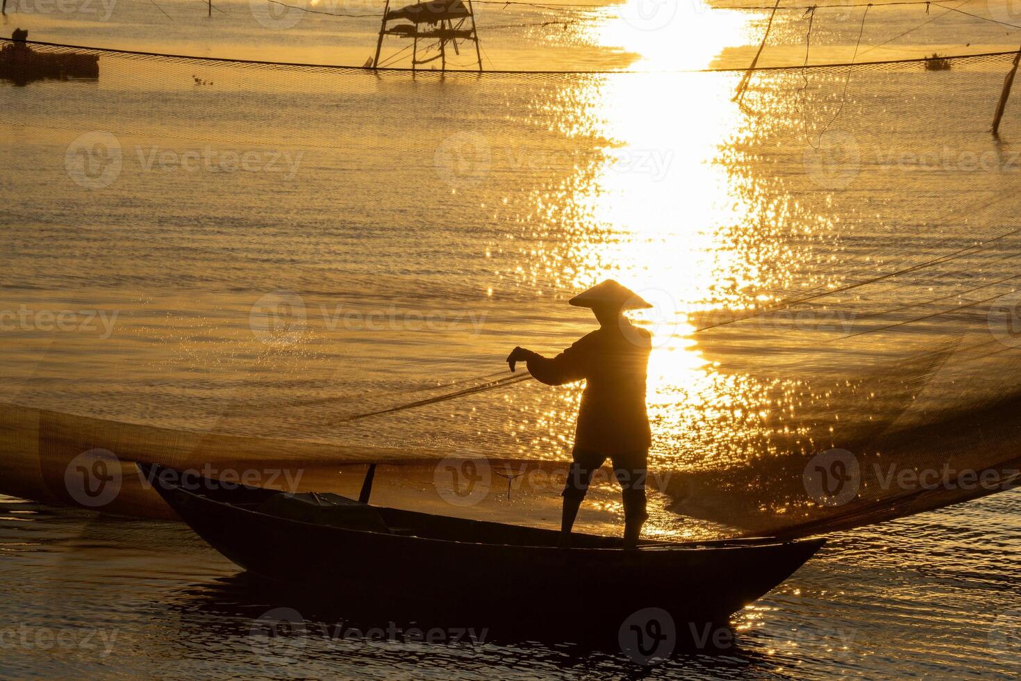 View of unidentified fisherman checks his nets in early morning on river in Hoi An ancient town, Quang Nam Province, Vietnam photo