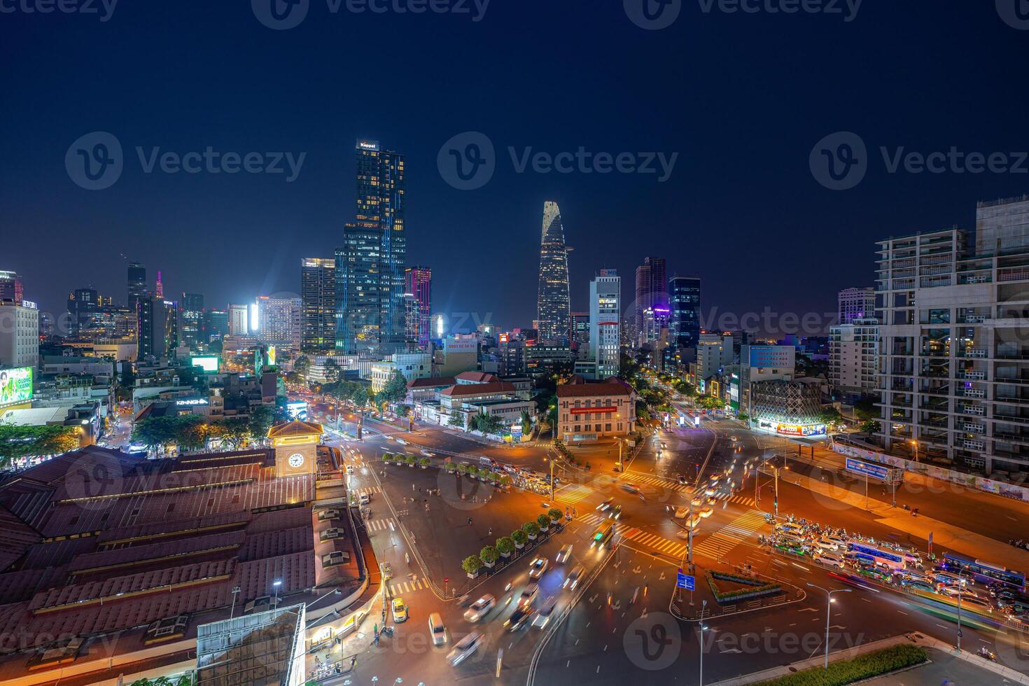 Night view of busy traffic in crowded intersection near Ben Thanh market in Ho Chi Minh city. Ben Thanh market is the symbol of Saigon, Vietnam photo