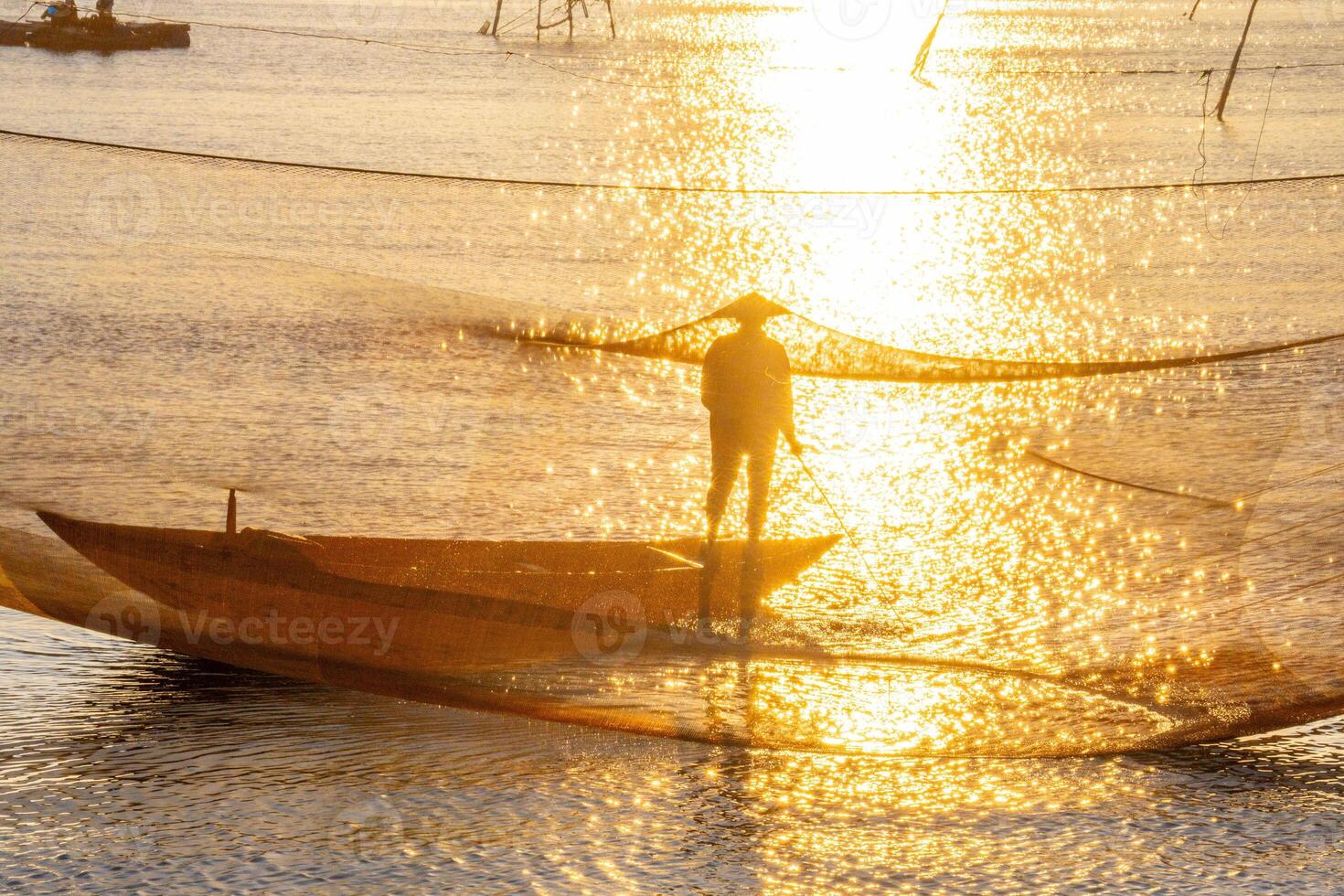 View of unidentified fisherman checks his nets in early morning on river in Hoi An ancient town, Quang Nam Province, Vietnam photo