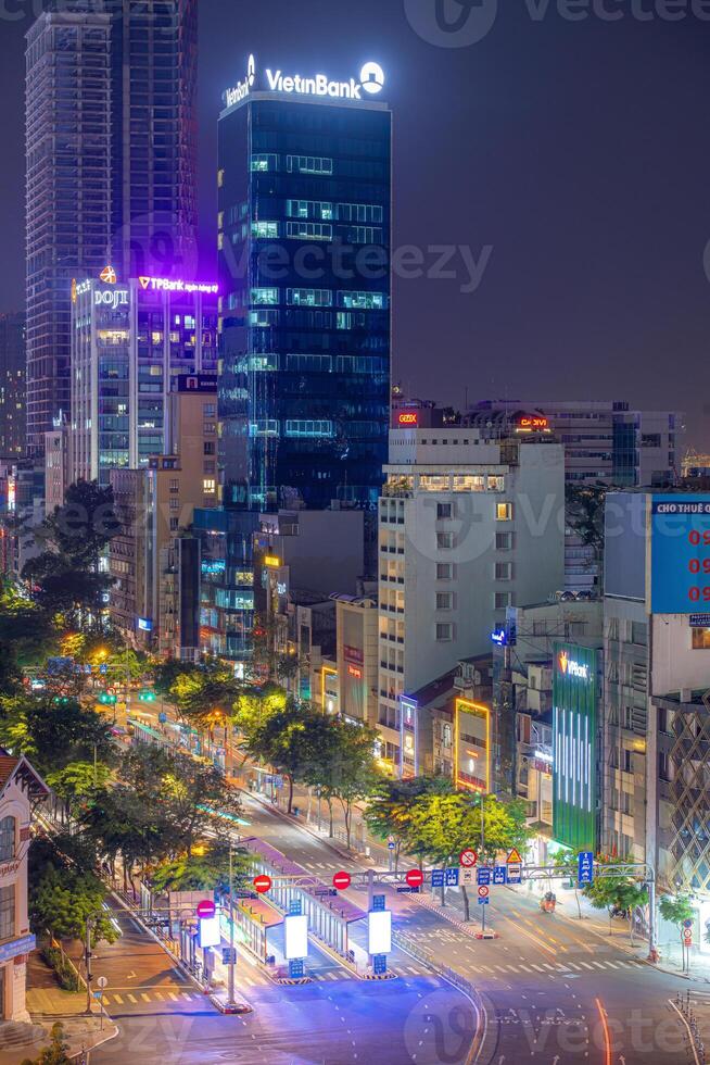 Night view of busy traffic in crowded intersection near Ben Thanh market in Ho Chi Minh city. Ben Thanh market is the symbol of Saigon, Vietnam photo