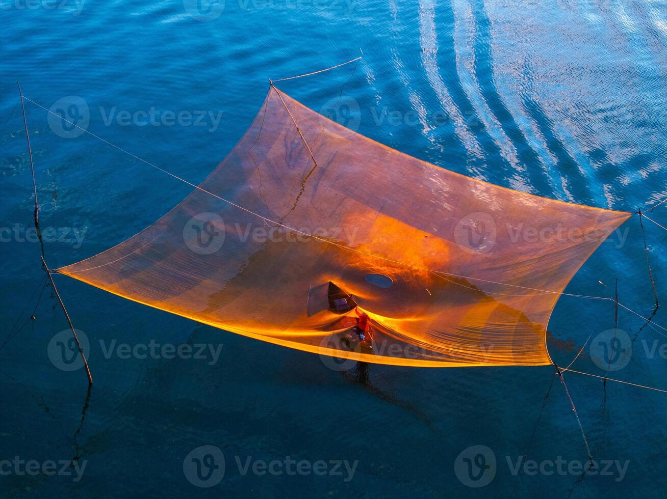 View of unidentified fisherman checks his nets in early morning on river in Hoi An ancient town, Quang Nam Province, Vietnam photo