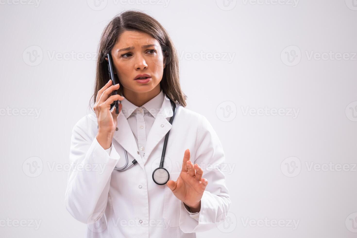 Portrait of doctor who is talking on phone with patient. photo