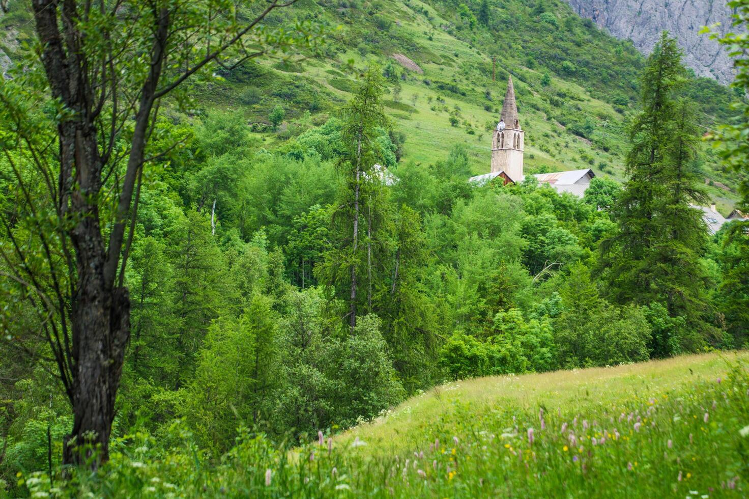 a church in the middle of a green valley photo