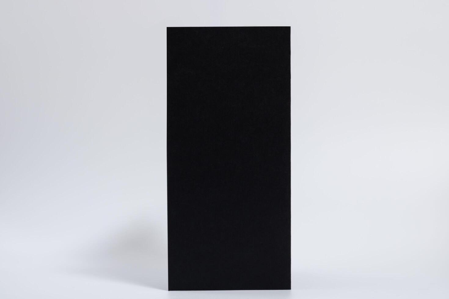mockup of a black vertical brochure on a white horizontal background photo