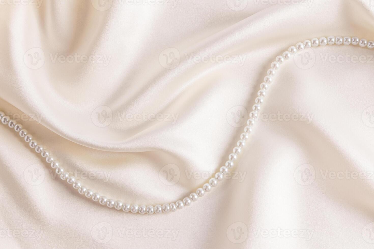 Chic wedding background beige, cream satin with soft waves of fabric and string of pearl beads. A copy of the space. cover, postcard, album photo