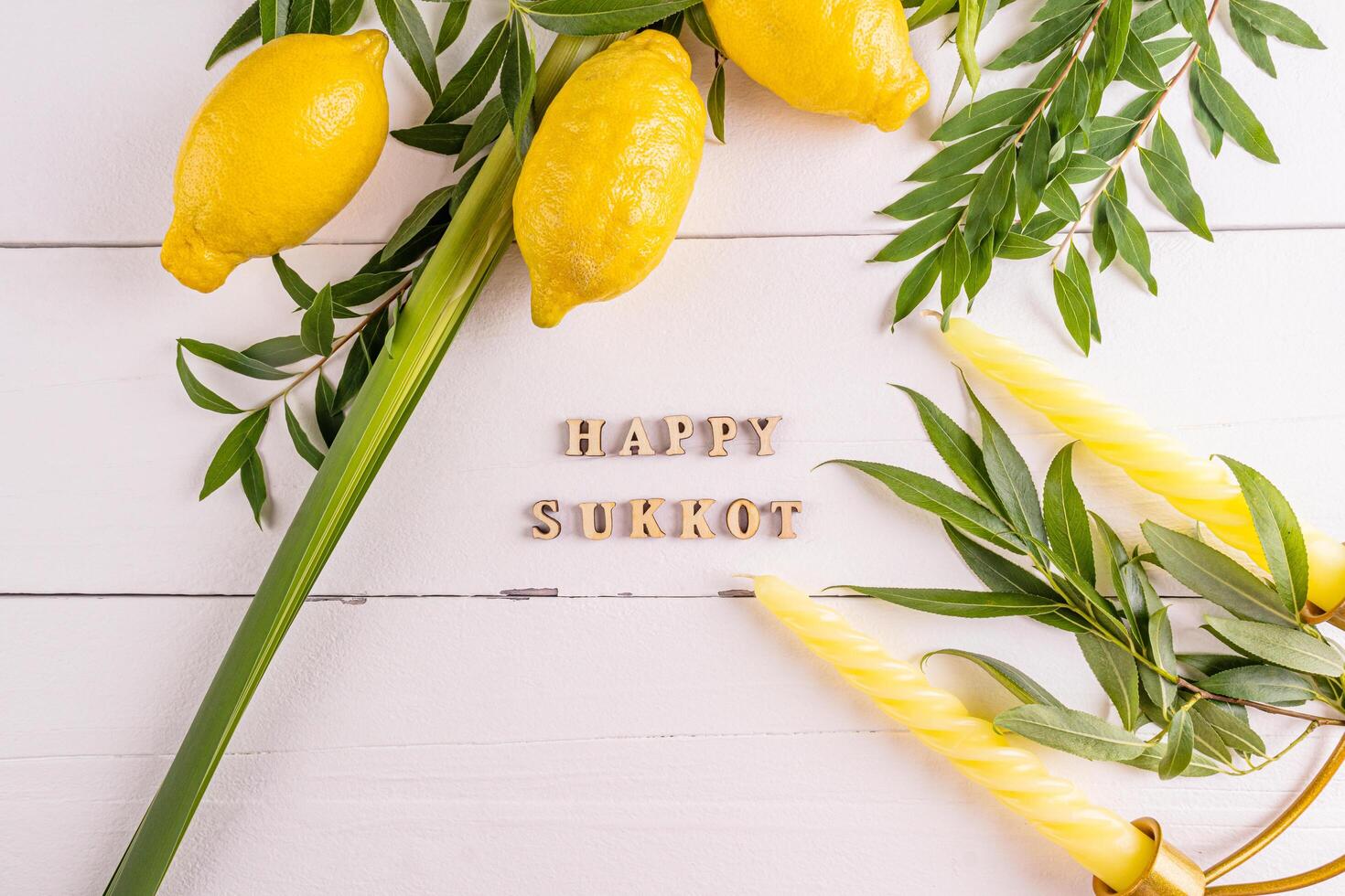 A beautiful festive backdrop for the Jewish harvest festival of Sukkot with traditional symbols and candles. white wooden background. photo
