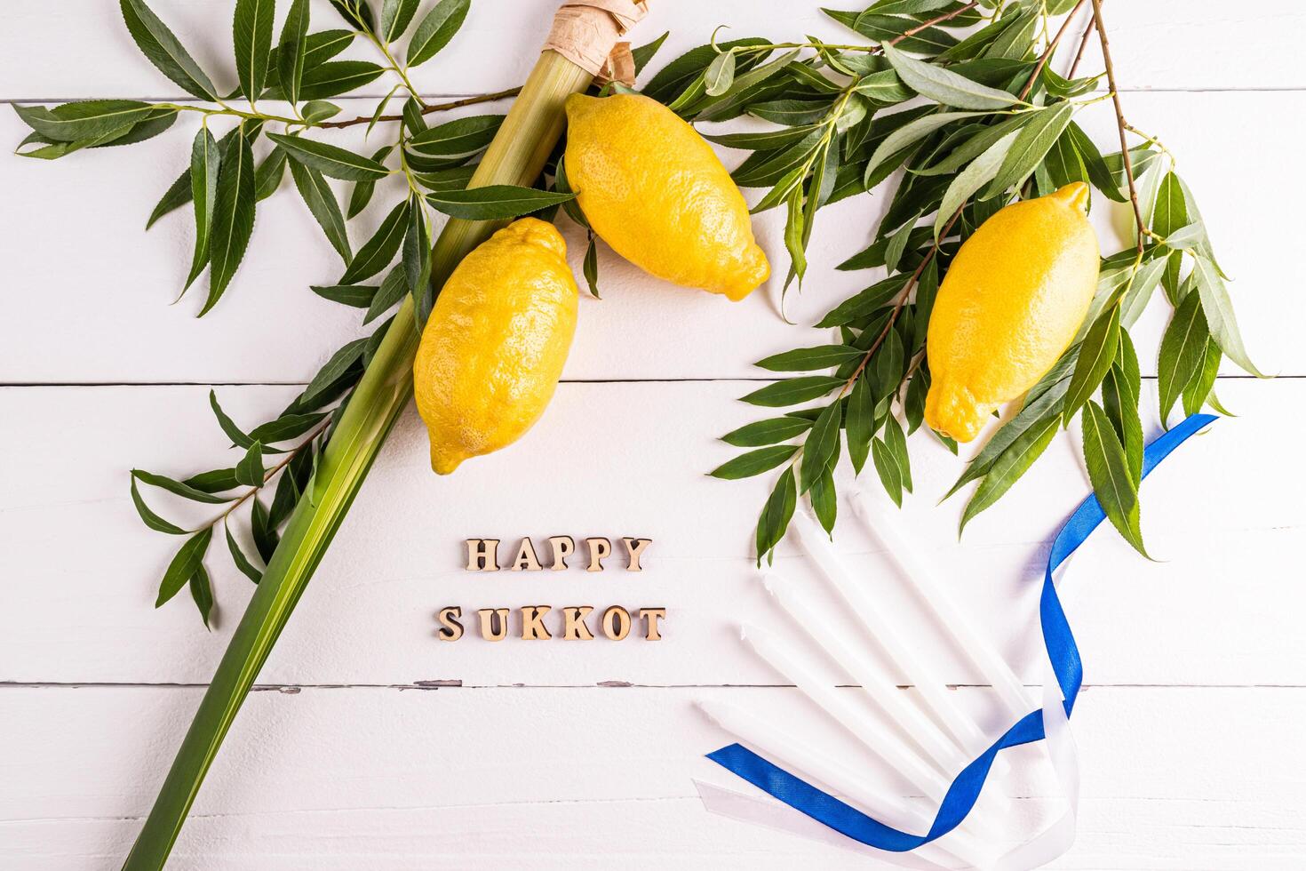 A beautiful festive background for the Jewish harvest festival of Sukkot with traditional symbols and candles. Wooden letters of the Sukkot. photo