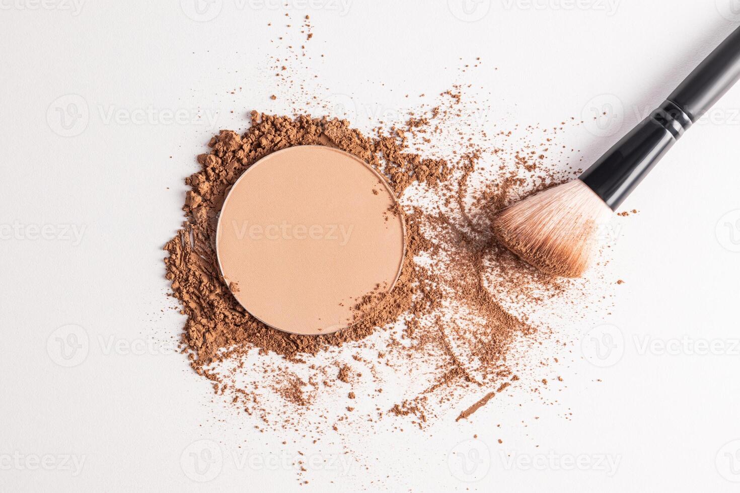 A sample of a round block of compact powder in a brown tone and a chic brush for applying makeup. loose powder sample. top view. layout for design photo
