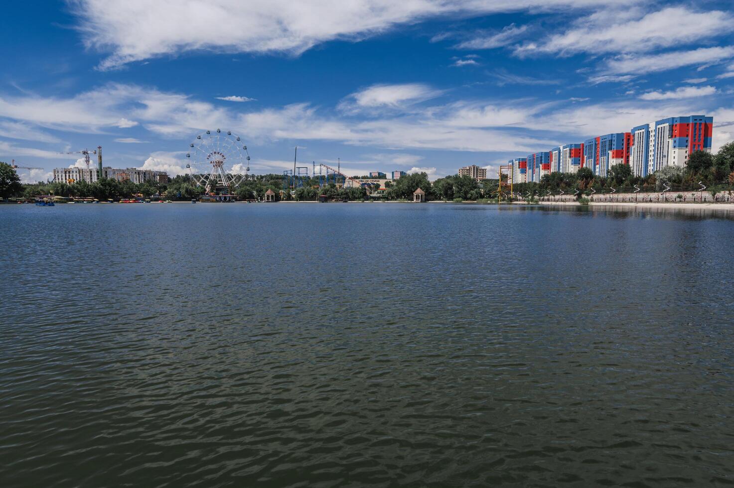 SHYMKENT, KAZAKHSTAN - JULY 07, 2023. View of Altyn Eye Park and Ferris wheel from the in Shymkent in summer photo