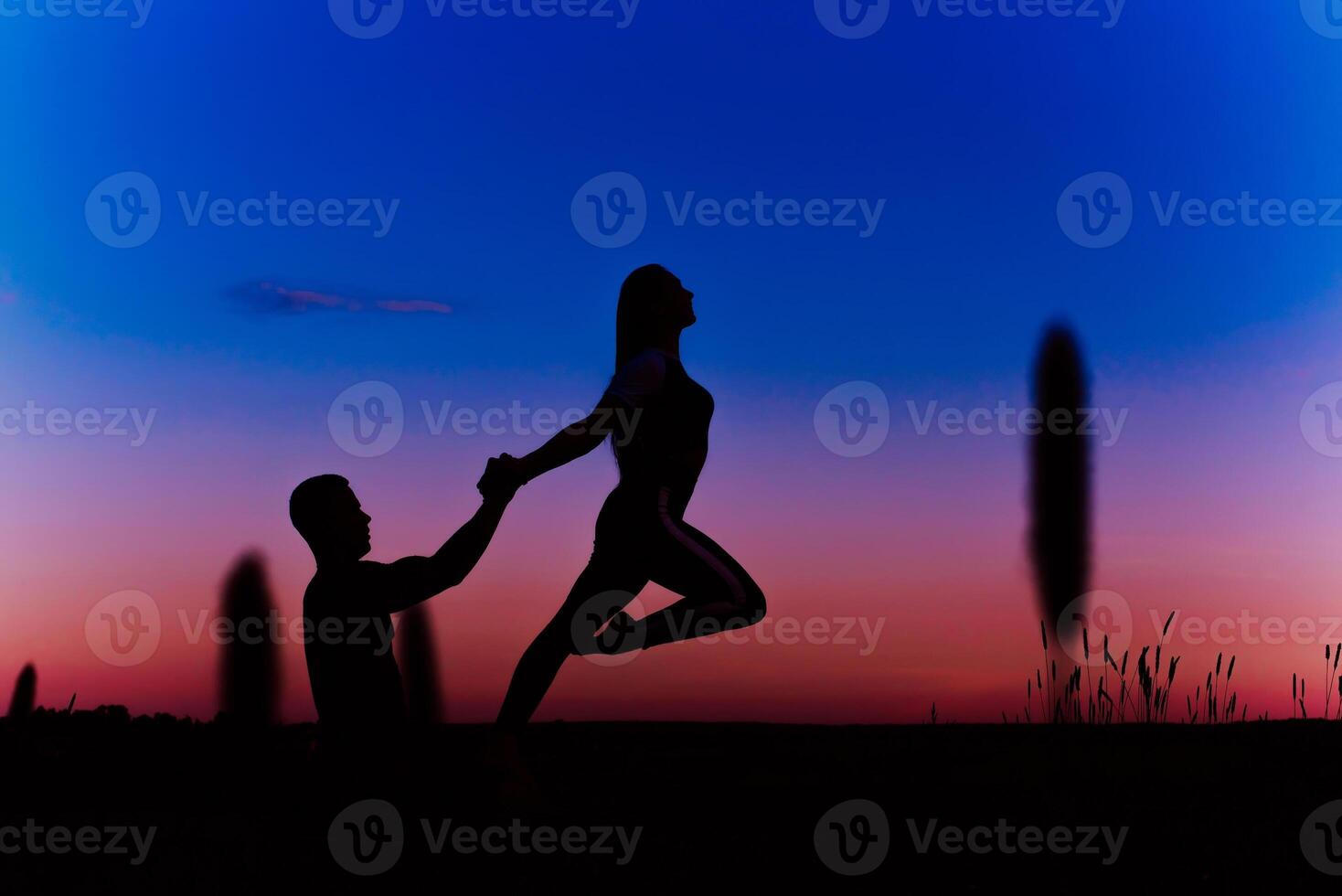 couple a man and a girl do a balance and stretching exercise in a yoga pose photo