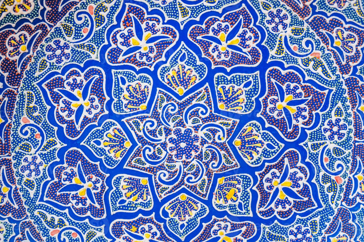 colorful pattern on oriental Uzbek ceramic plates hand-painted closeup in Arabesque style photo