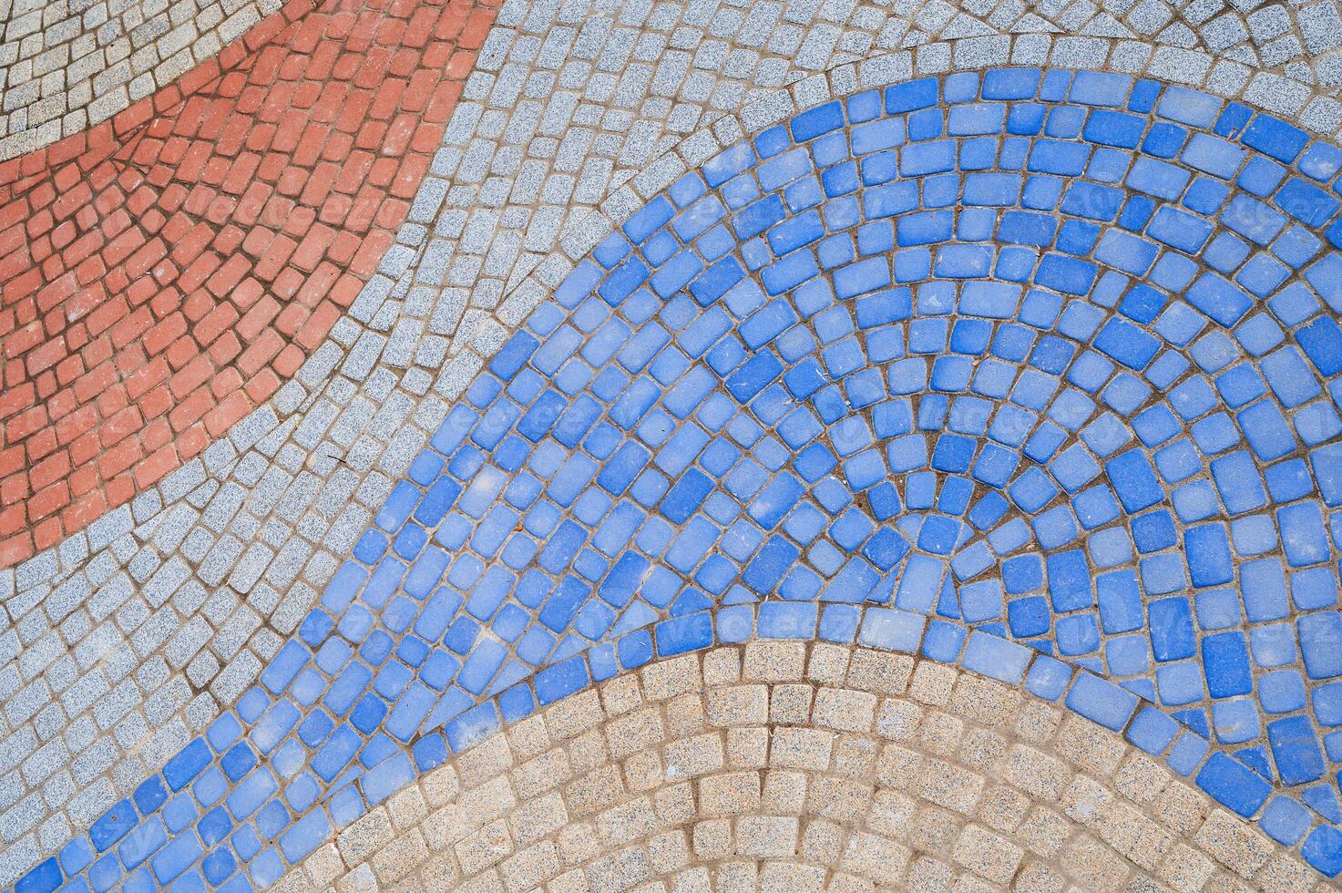 texture of sidewalk paved with multicolored paving slabs photo