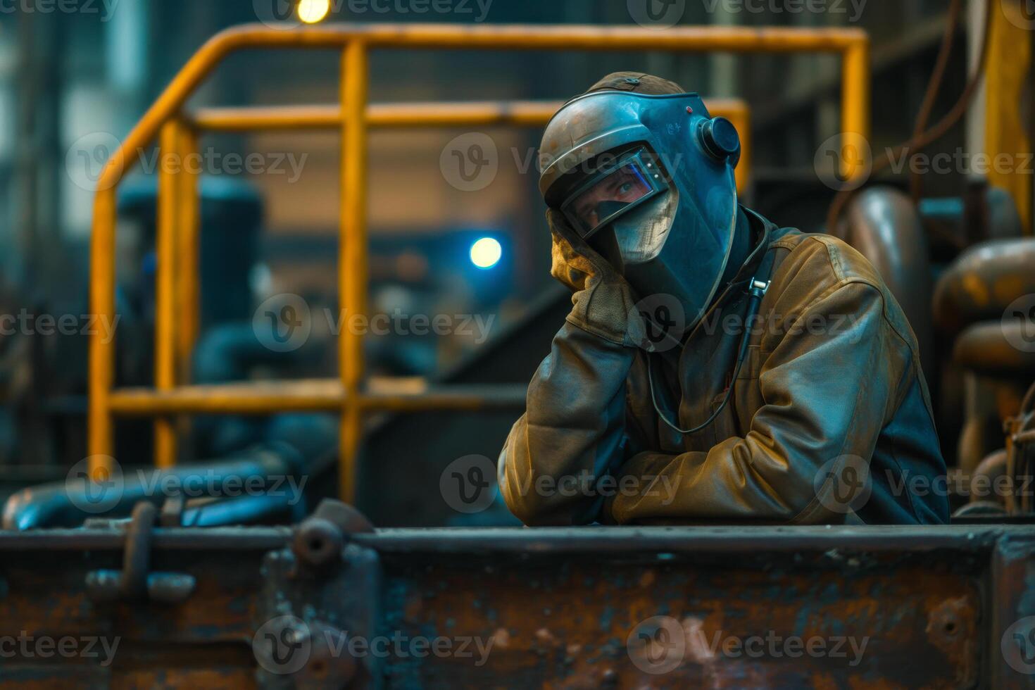 Tired Industrial Worker in Protective Gear Resting in a Factory Setting photo