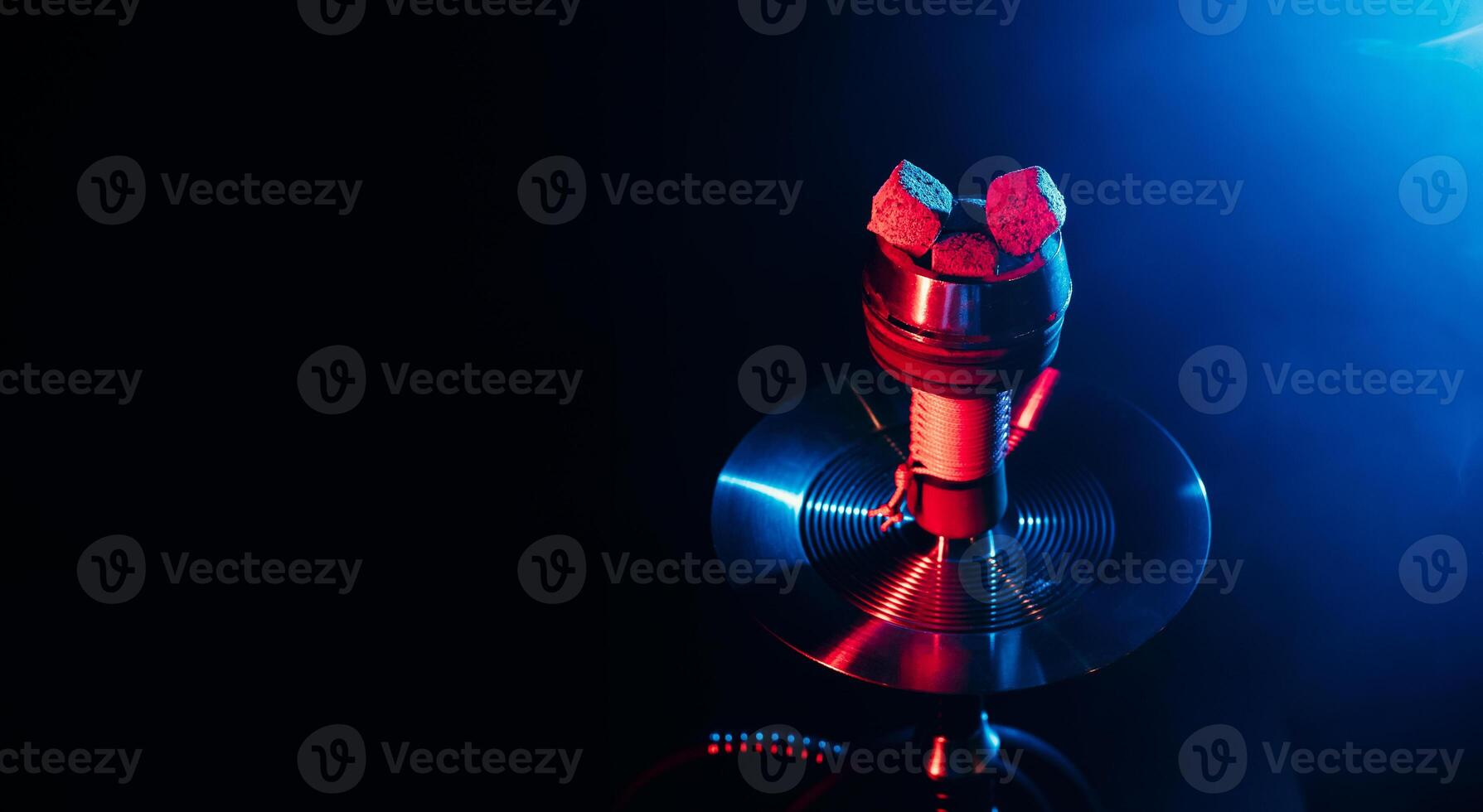 red hot coals of a shisha in a hookah bowl on a black background photo