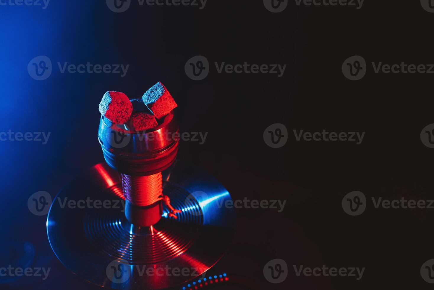 red hot coals of a shisha in a hookah bowl on a black background photo