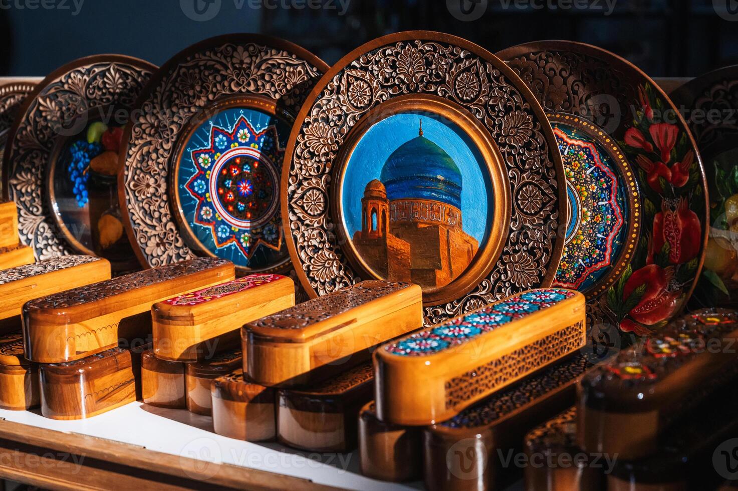 handmade Uzbek wooden gift plates and caskets with wood carvings hand-painted traditional patterns in souvenir shop of Uzbekistan photo
