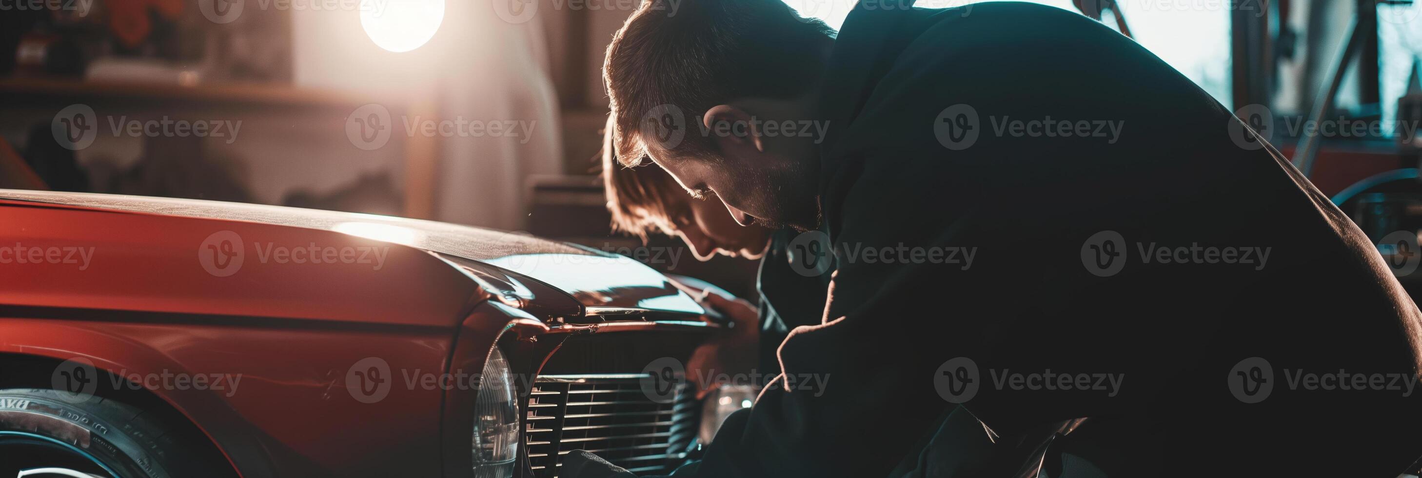 Mechanic Repairing Vintage Car in Workshop with Warm Lighting photo