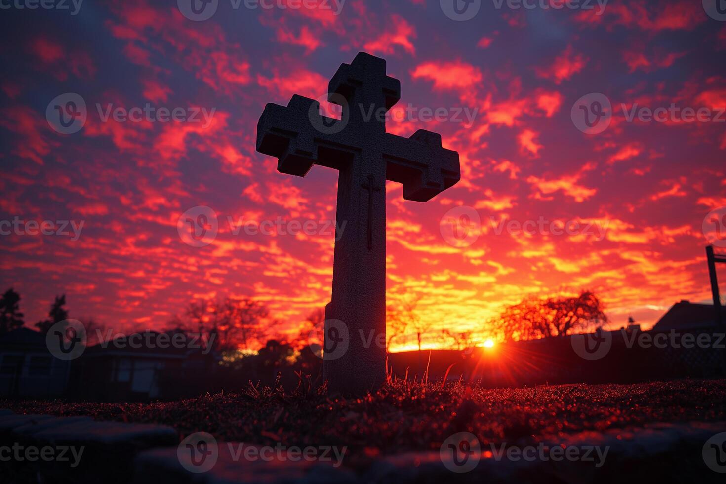 Sunset Silhouette of Stone Cross Against Vibrant Cloudy Sky photo