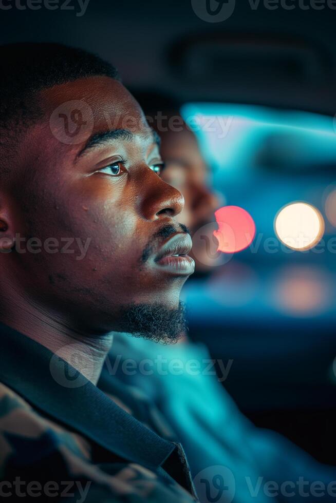 Pensive Young Man Riding in Car at Night with Colorful Bokeh Background photo