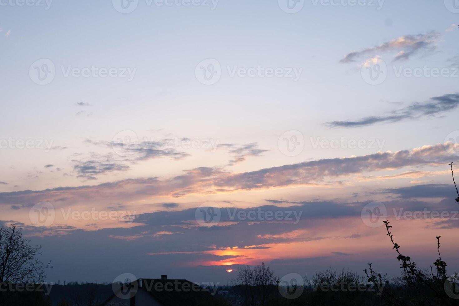 sunset spring sky over the roof of a house photo
