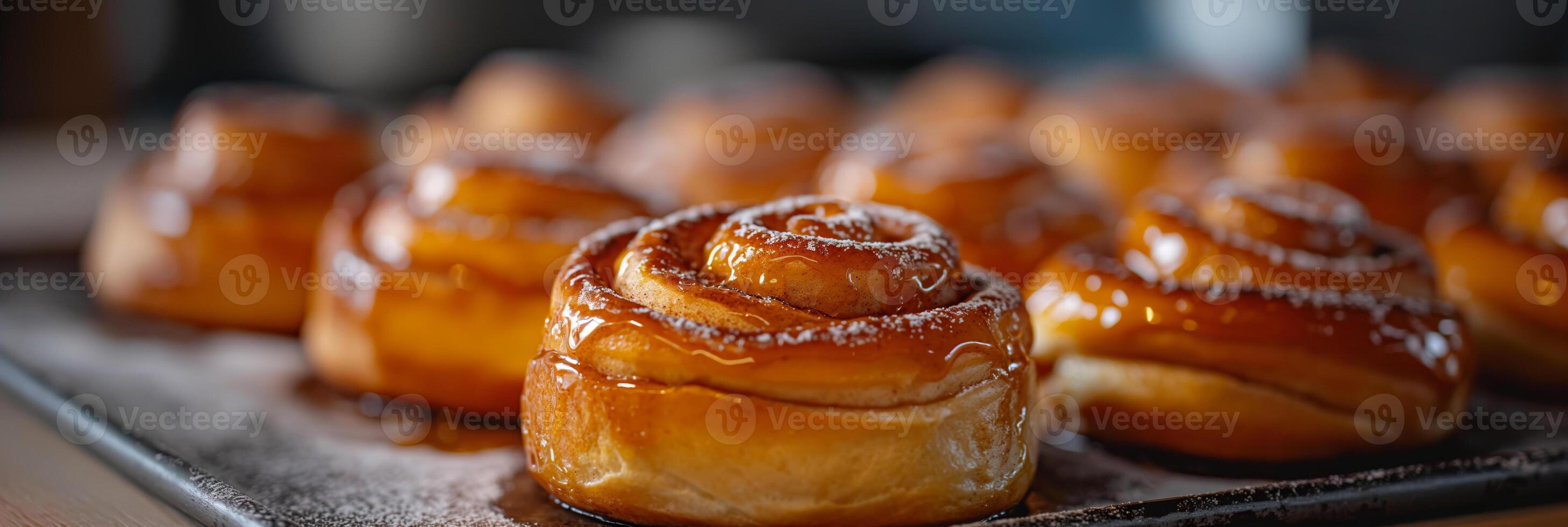 Freshly Baked Cinnamon Rolls With Glazed Topping on a Baking Tray photo