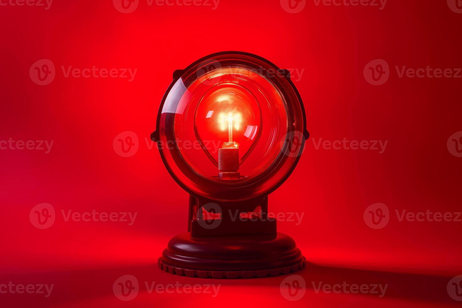 Vintage Red Light Bulb in Retro Round Lamp Against Bold Red Background photo