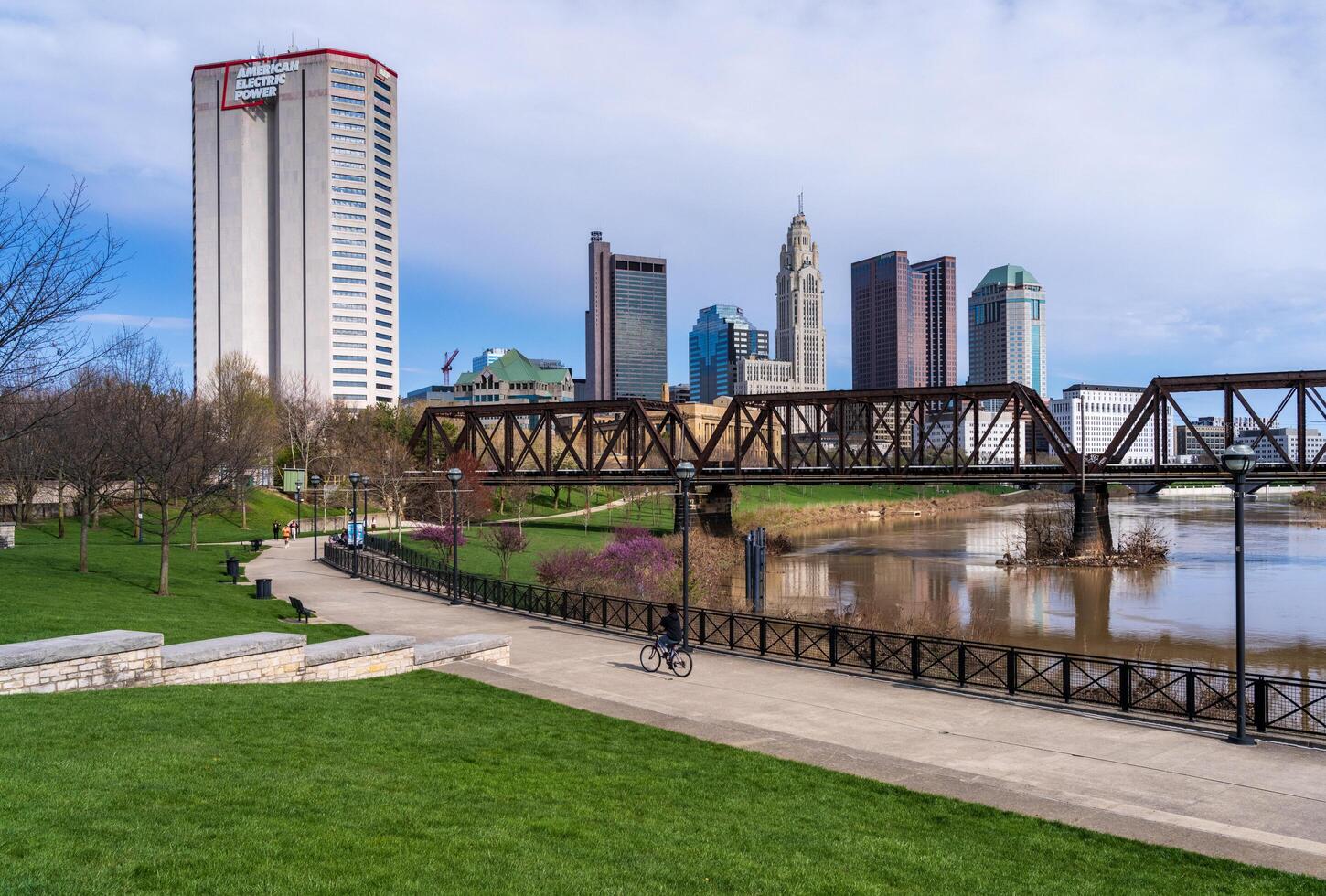 Columbus, OH - 7 April 2024. Waterfront view of the downtown financial district from the River Scioto through a railroad truss bridge photo
