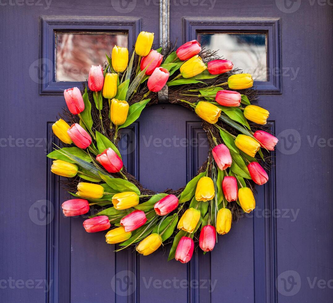 Arrangement of tulips in circular wreath on exterior door marking the start of Easter and springtime photo