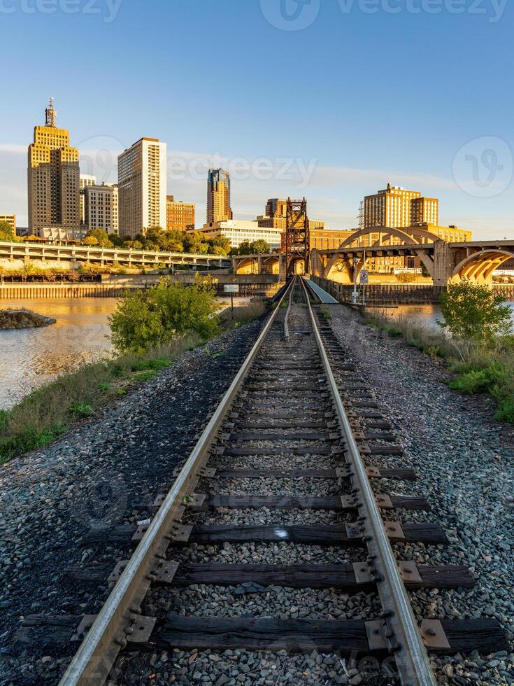 Early morning cityscape of St Paul and Twin Cities in Minnesota looking down rails of railroad bridge photo