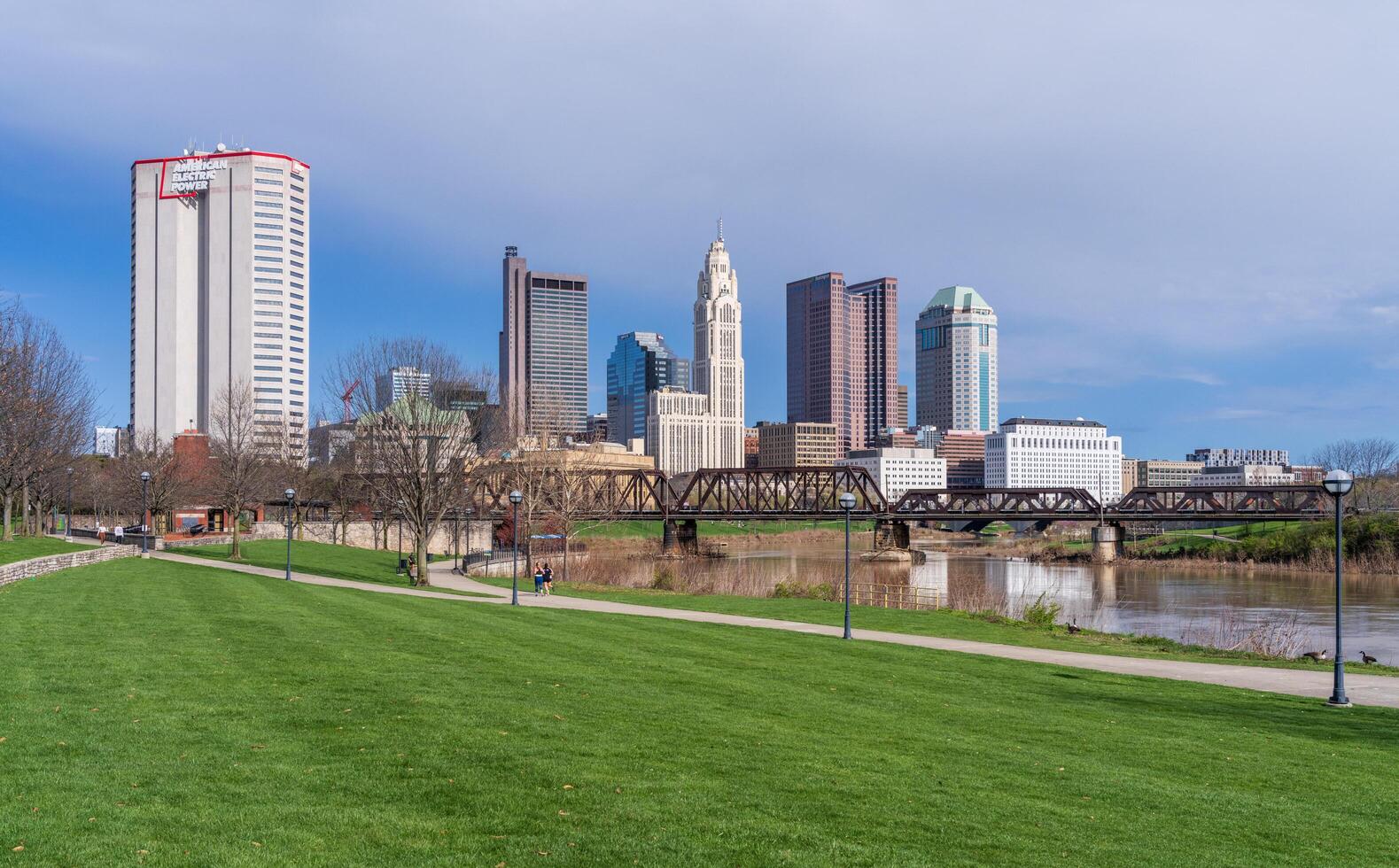 Columbus, OH - 7 April 2024. Waterfront view of the downtown financial district from the River Scioto through a railroad truss bridge photo
