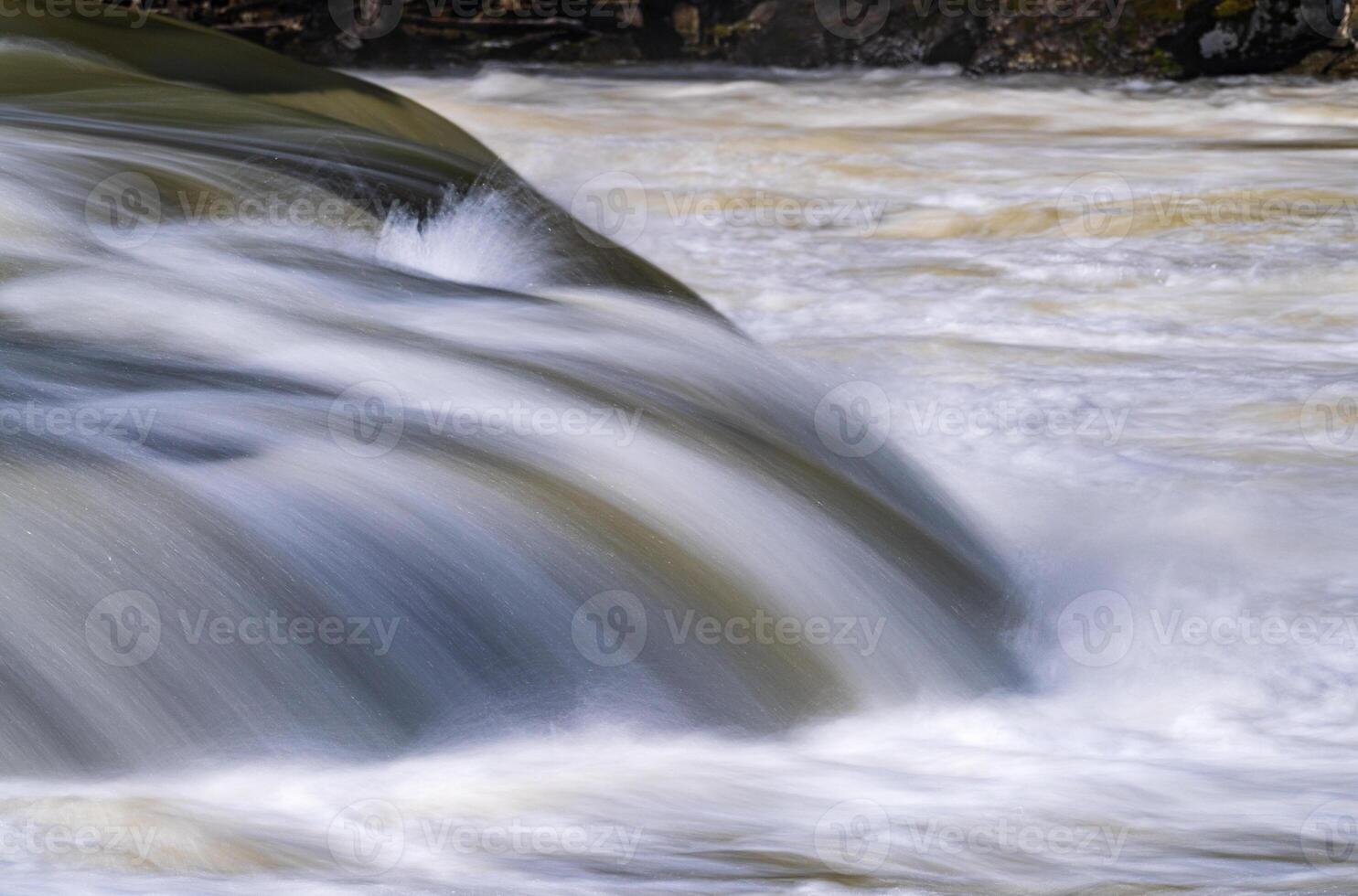 Silky blurred exposure of raging water flowing over rocks of Valley Falls State Park on Tygart River near Fairmont West Virginia photo