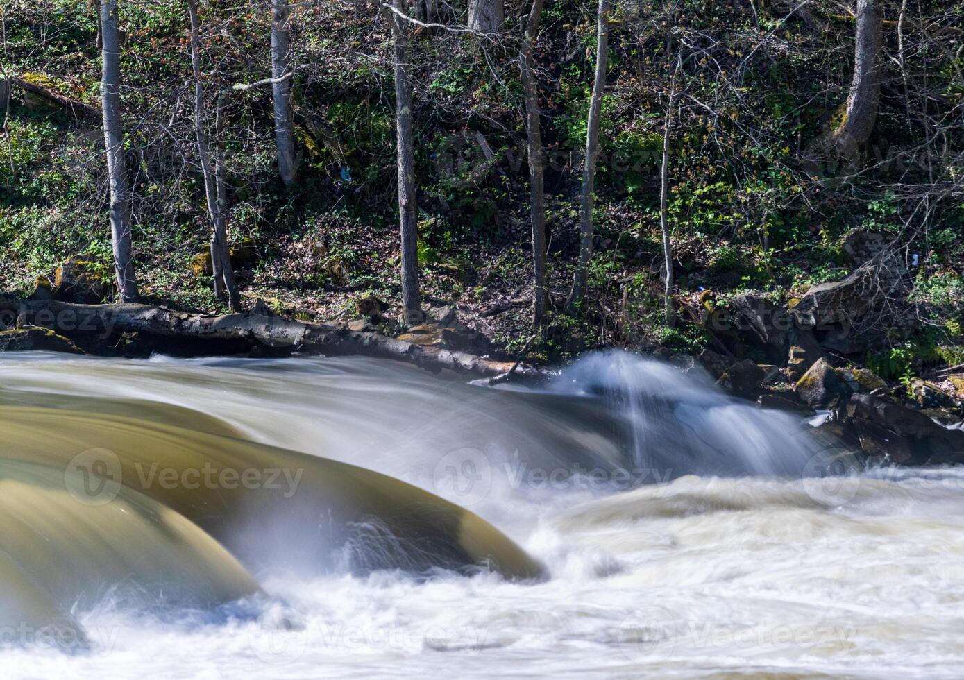 Silky blurred exposure of raging water flowing over rocks of Valley Falls State Park on Tygart River near Fairmont West Virginia photo