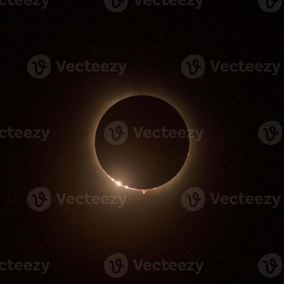 HD images of the solar eclipse in 2024 with the moon finally covering the sun. Baily's beads of light seen through canyons on the moon surface photo