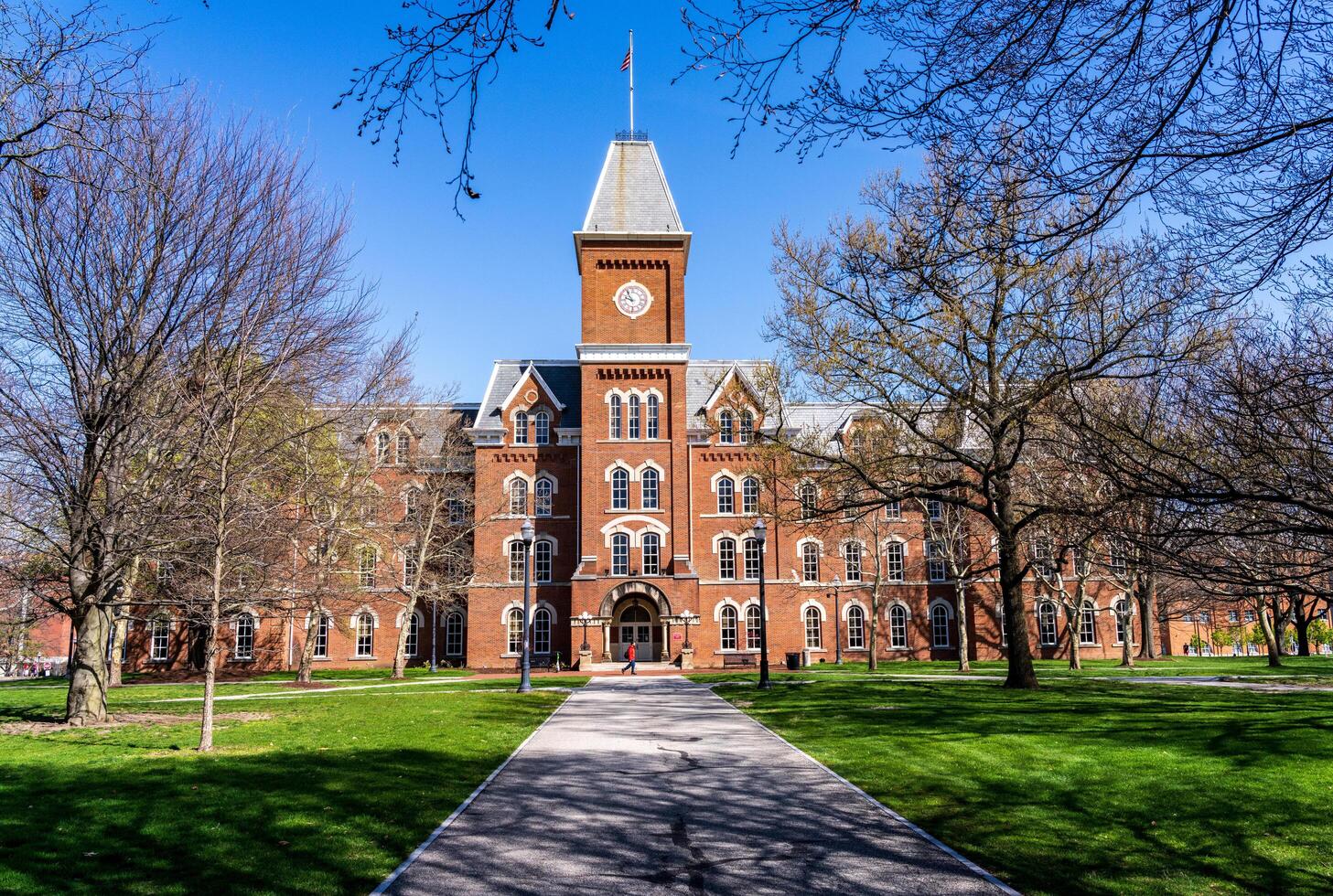 Columbus, Ohio - 8 April 2024. Student passes the entrance to historic University Hall on the Oval quadrangle at Ohio State University in Columbus OH photo
