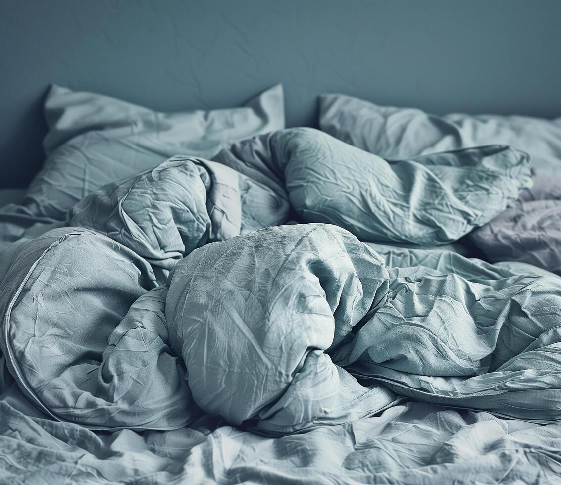 Cozy modern bedroom with rumpled bedding in soft blue tones photo