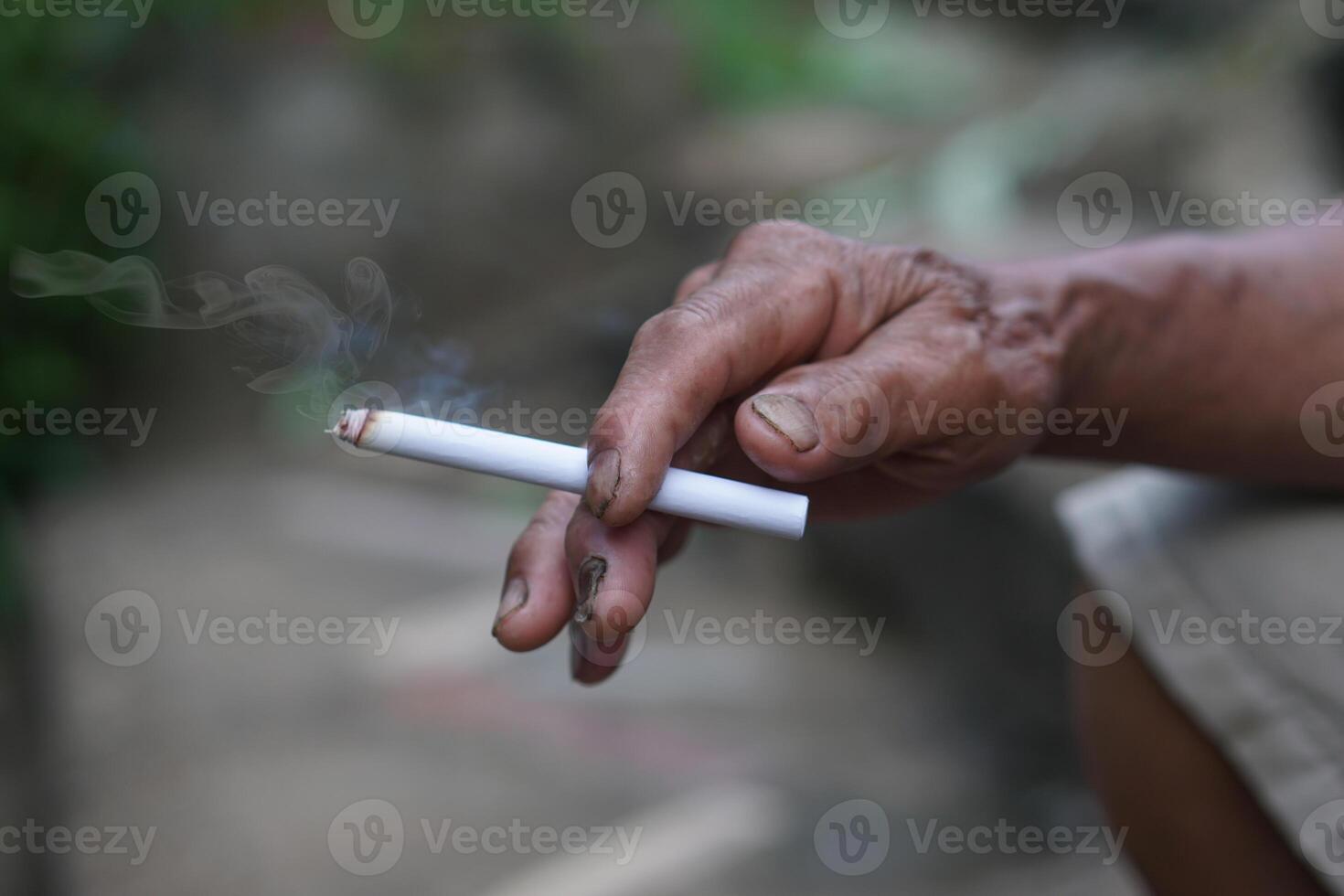 Close up unhealthy hand holds homemade cigarette for smoking. Concept, smoking is bad for health. Private favorite for relaxation but can cause health problems and bad smell. photo