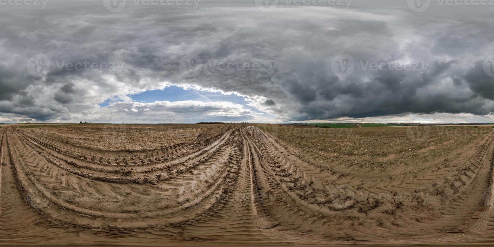 hdri 360 panorama on dirt muddy road among fields in spring nasty day with storm clouds in equirectangular full seamless spherical projection, for VR AR virtual reality content photo