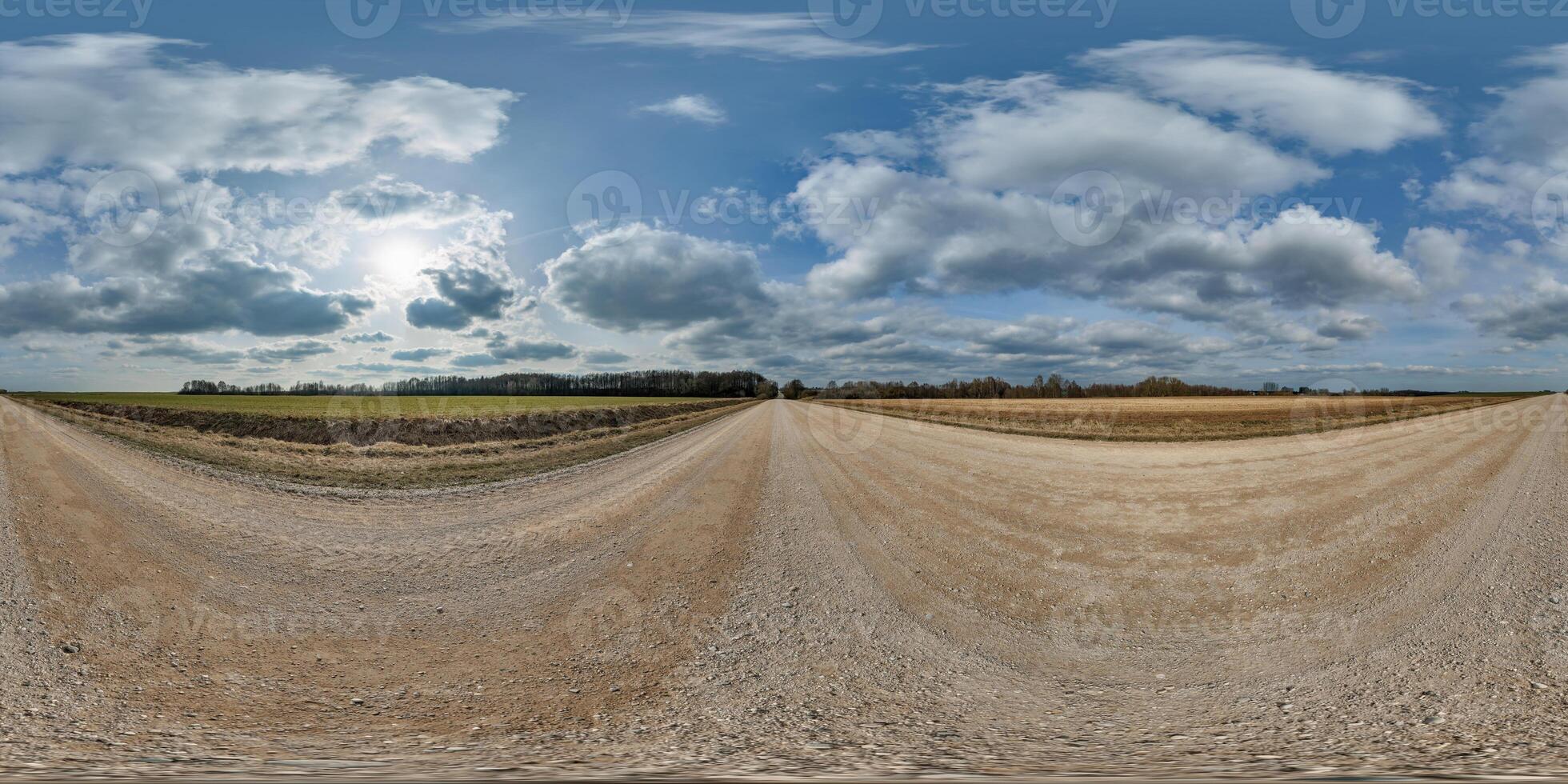hdri 360 panorama on gravel road among fields in spring nasty day with awesome clouds in equirectangular full seamless spherical projection, for VR AR virtual reality content photo