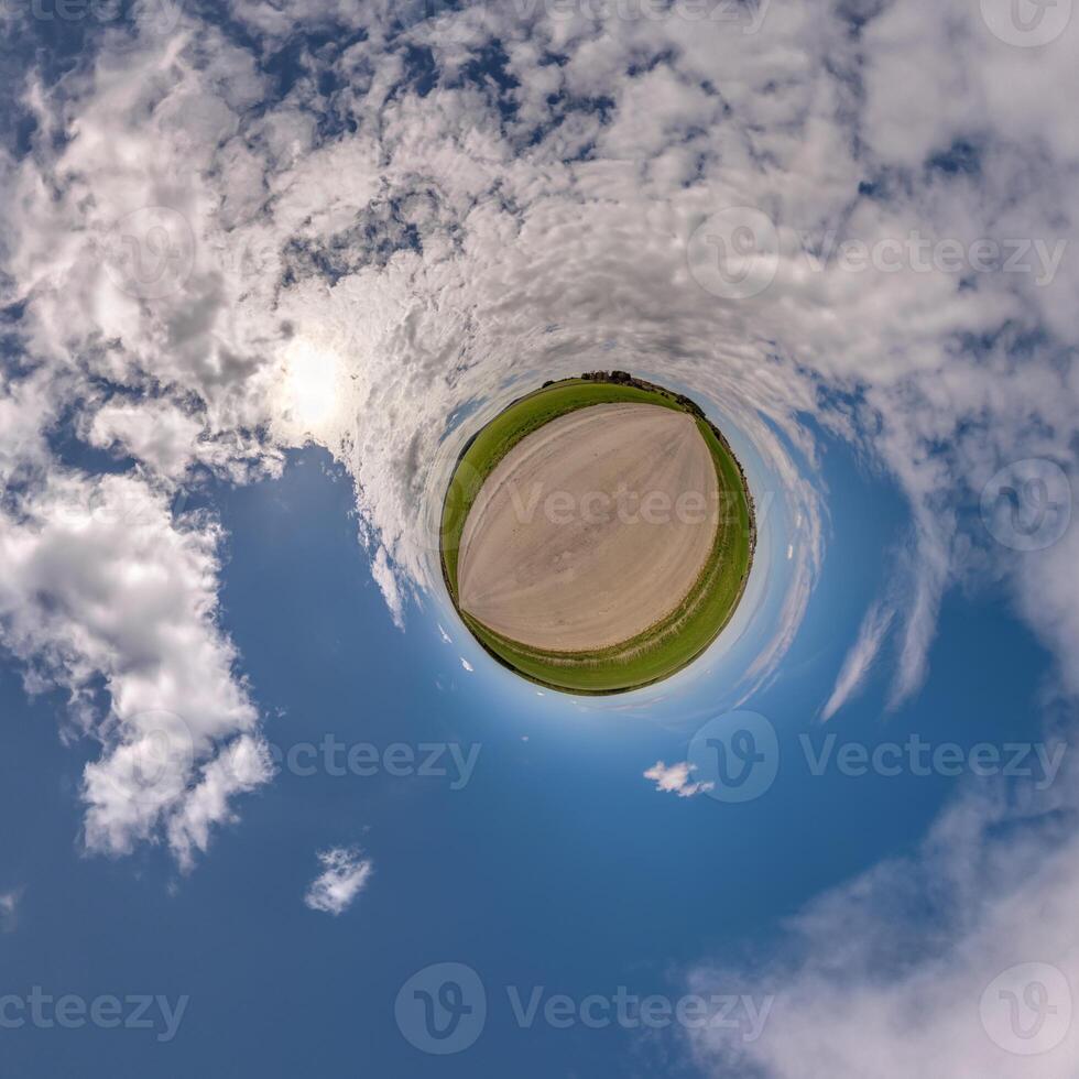 simple little tiny planet without buildings in blue sky with beautiful clouds. Transformation of spherical panorama 360 degrees. Spherical abstract aerial view. Curvature of space. photo