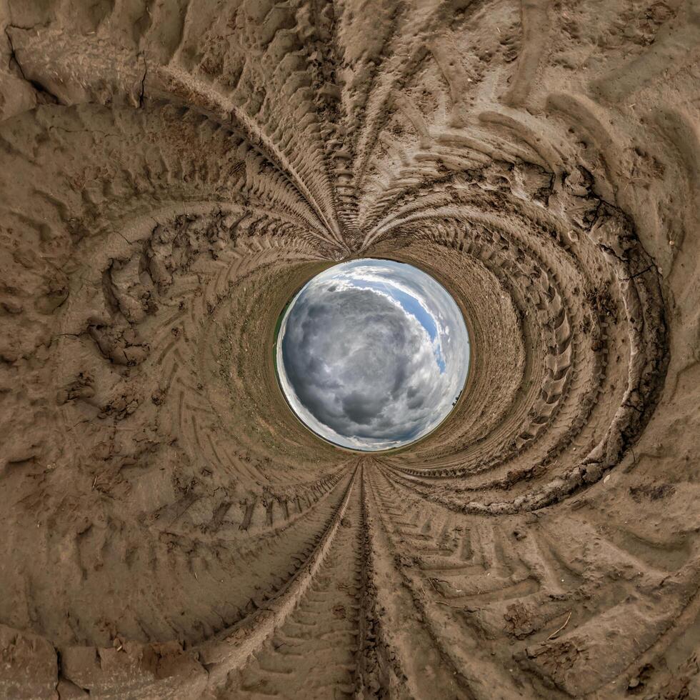 blue hole sphere or globe little planet inside sand or dry ground frame background with tractor tracks photo